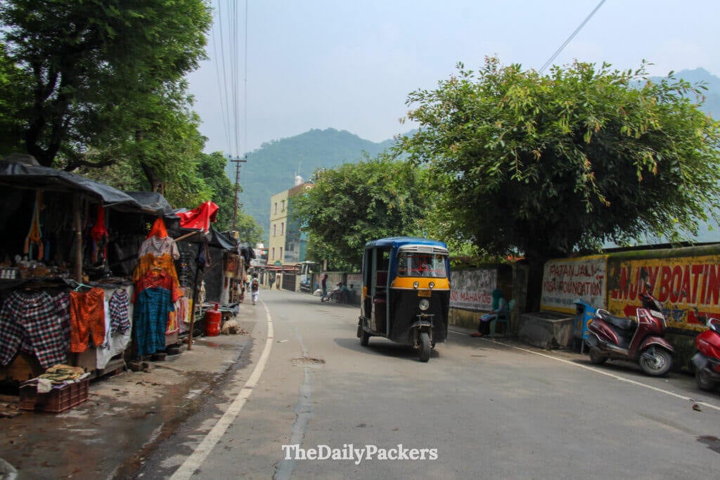 Local street in Rishikesh with tuk-tuk, market stalls and everyday local life