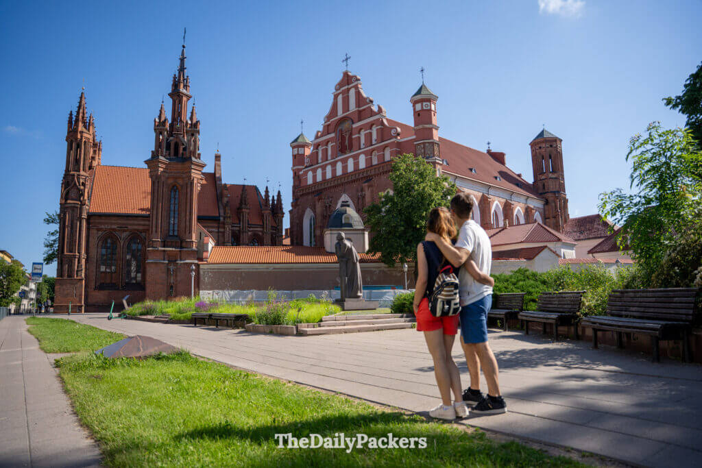 Couple admiring St Anne’s Church in Vilnius Old Town, Lithuania