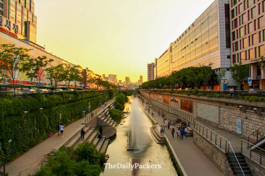 Cheonggyecheon Stream at sunset with fountains and city life in central Seoul