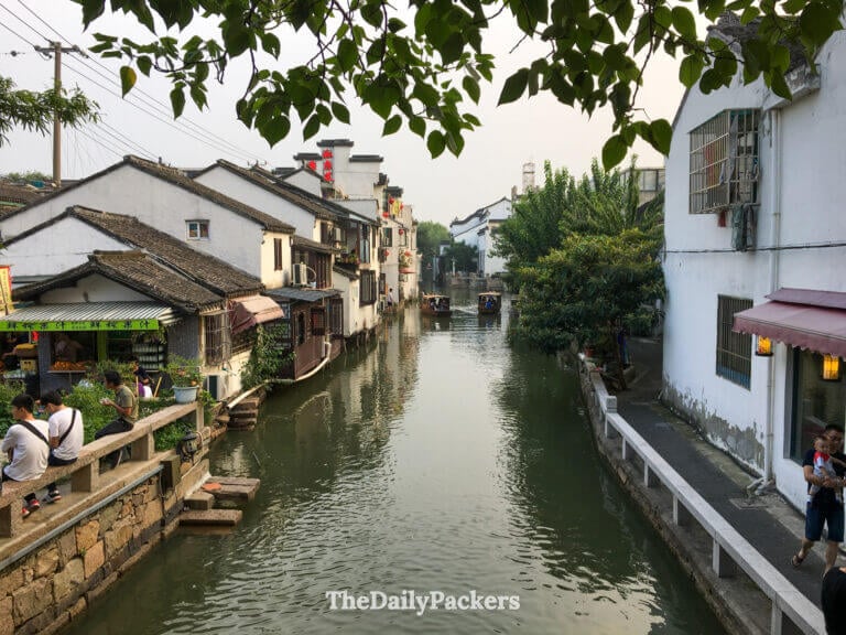 Canal lined with traditional houses and boats in Suzhou old town, one of the best places to visit in MAy