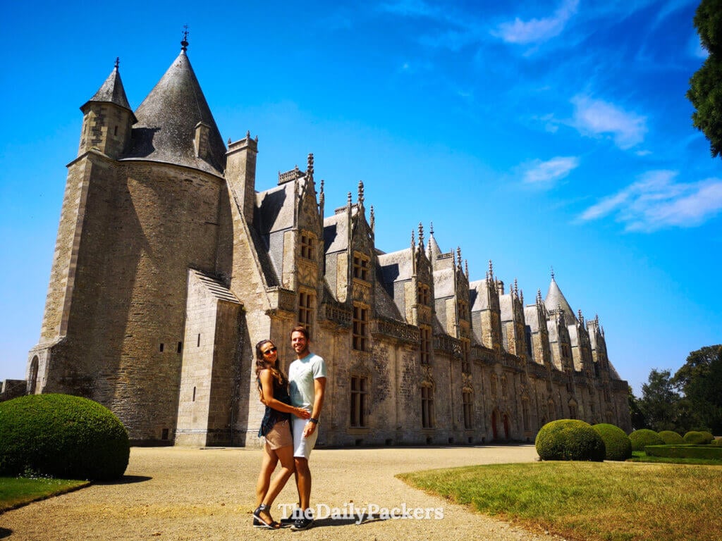Couple posing in front the old Josselin Castle and gardens, one of the best places to visit in September