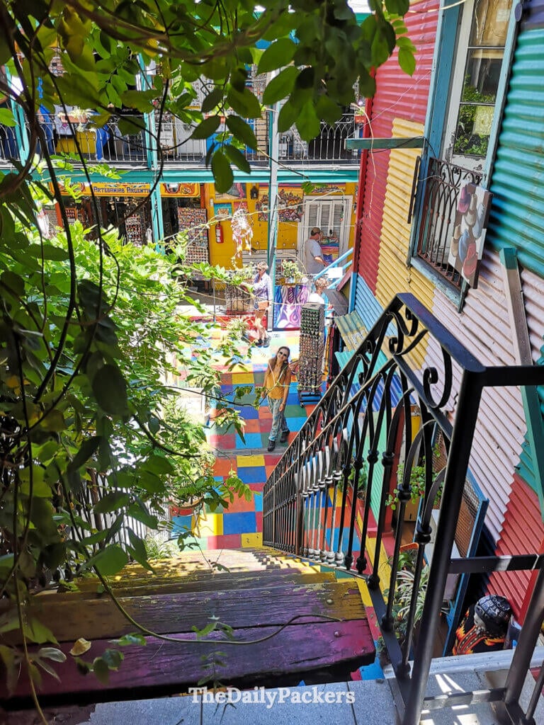 View from the stairs looking down into the Quinquela Martín patio in La Boca, Buenos Aires, with multicolored floors and visitors below.