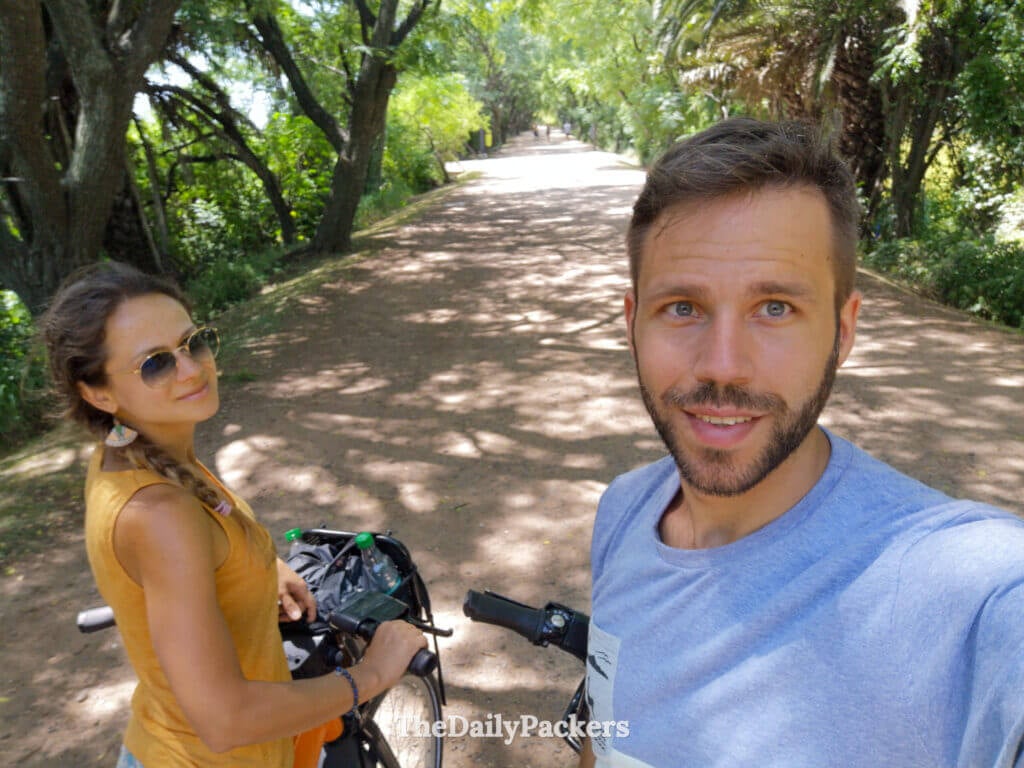 Couple taking a selfie with bicycles on a dirt path in Costanera Sur Ecological Reserve, Buenos Aires, enjoying a nature break from the city.