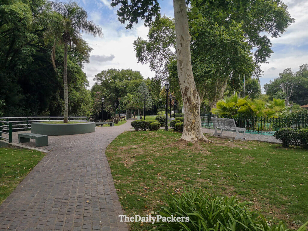 Plaza Daniel María Cazón in Tigre, featuring green spaces, benches, and historic buildings near the riverfront.