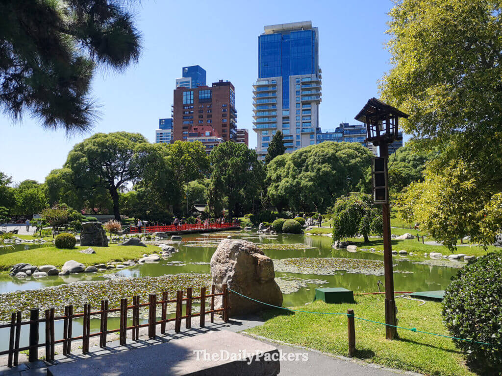 Serene pond scene inside the Japanese Garden of Buenos Aires with red bridges, rocks, and carefully maintained vegetation