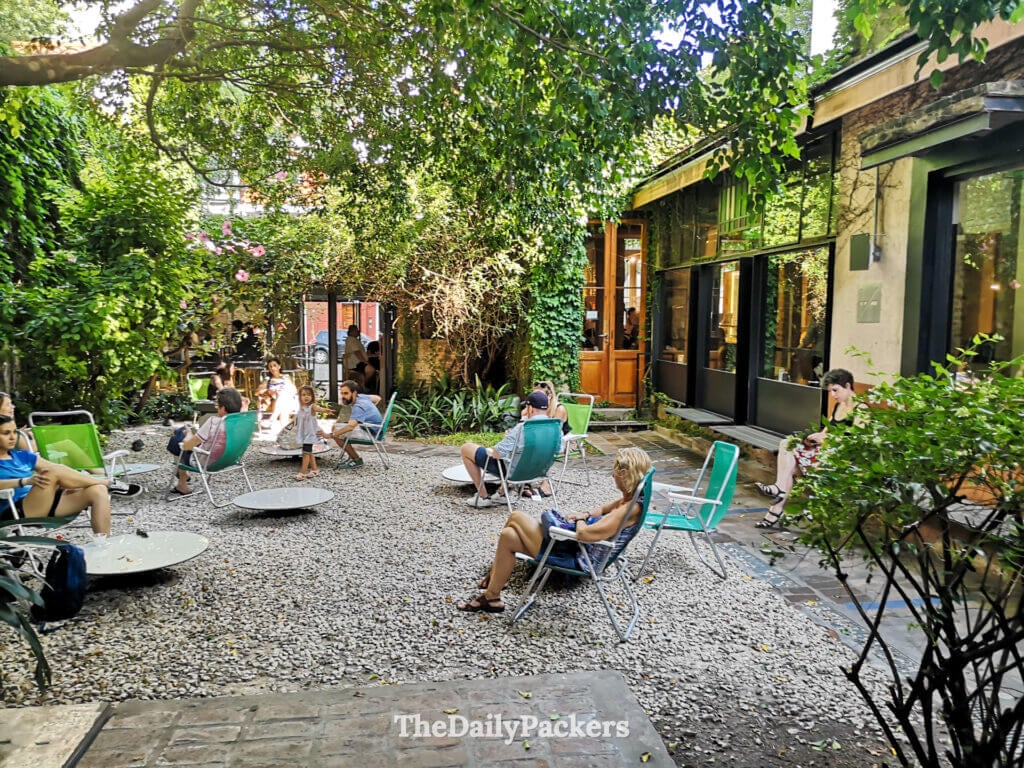Outdoor garden seating at Rapa Nui café in Buenos Aires, a popular spot to enjoy ice cream and coffee surrounded by greenery.