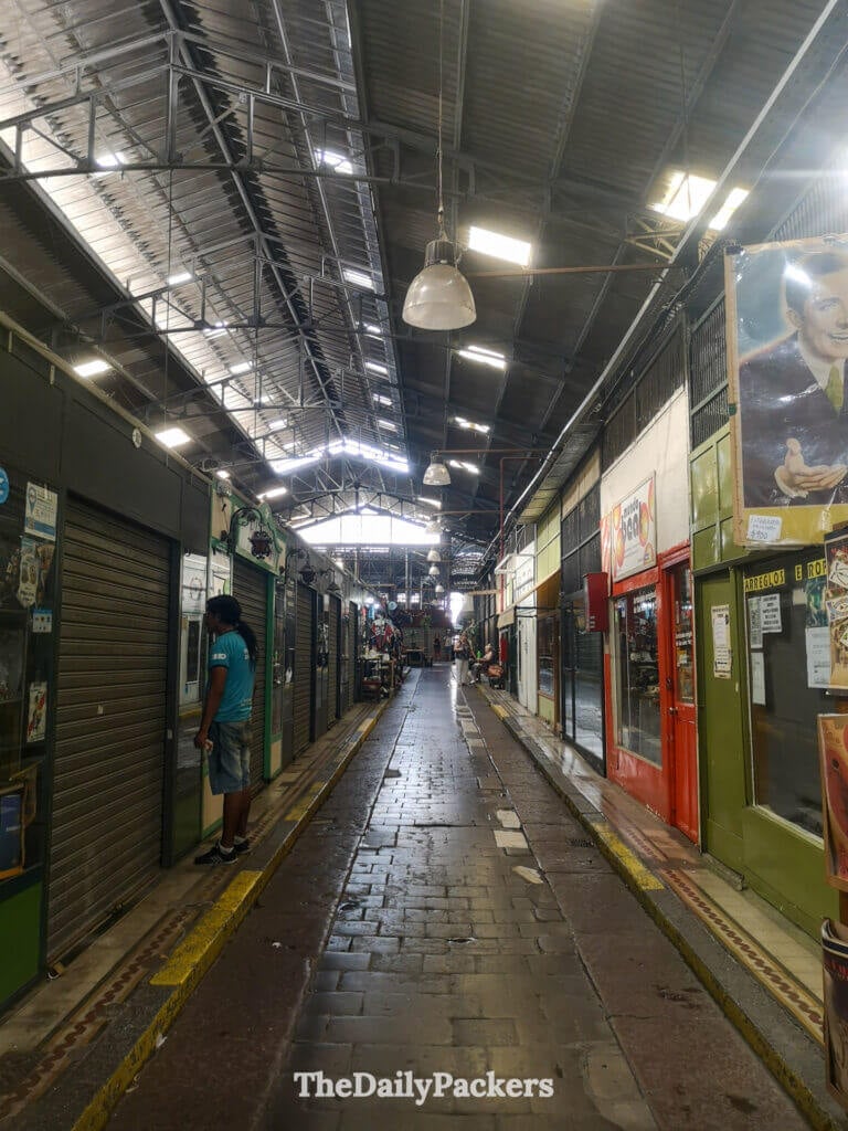 Aisle inside San Telmo Market in Buenos Aires, featuring vintage-style stalls, closed shutters, and traditional market structure.