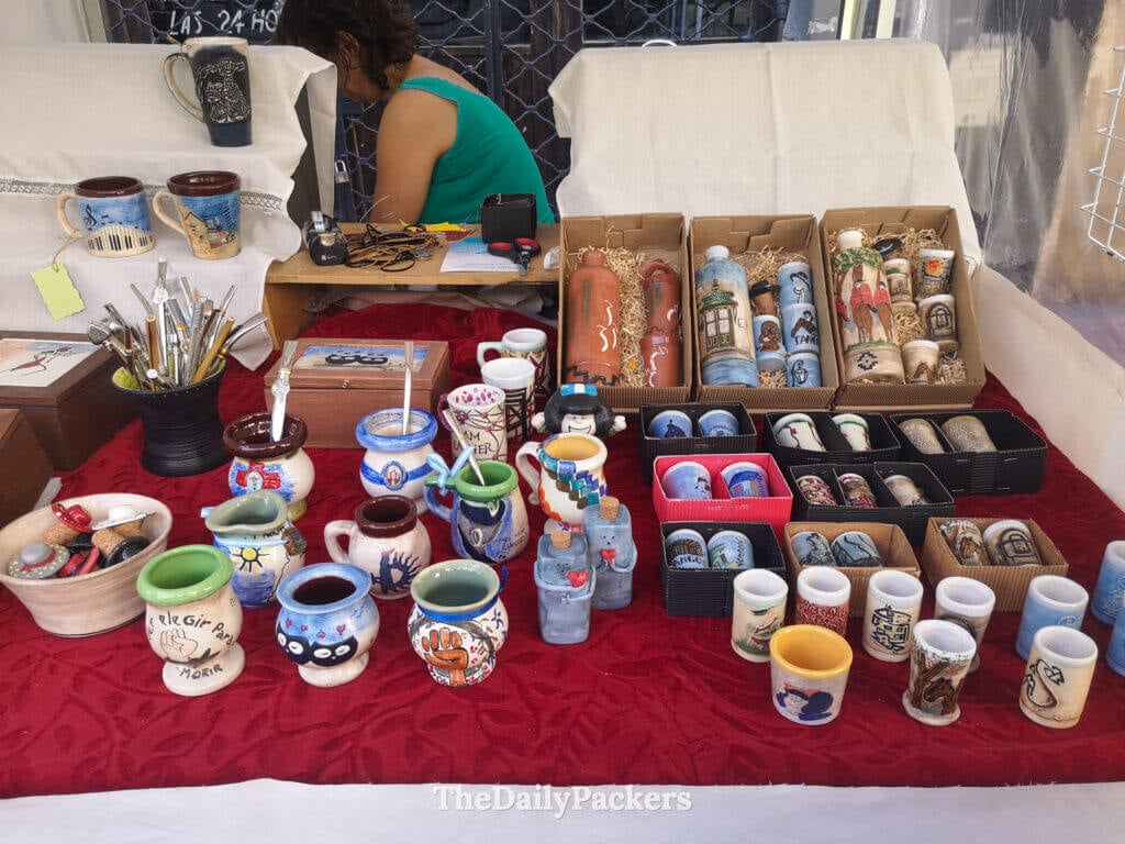 Handcrafted mate cups, mugs, and souvenirs displayed at a stall during the San Telmo street market in Buenos Aires.