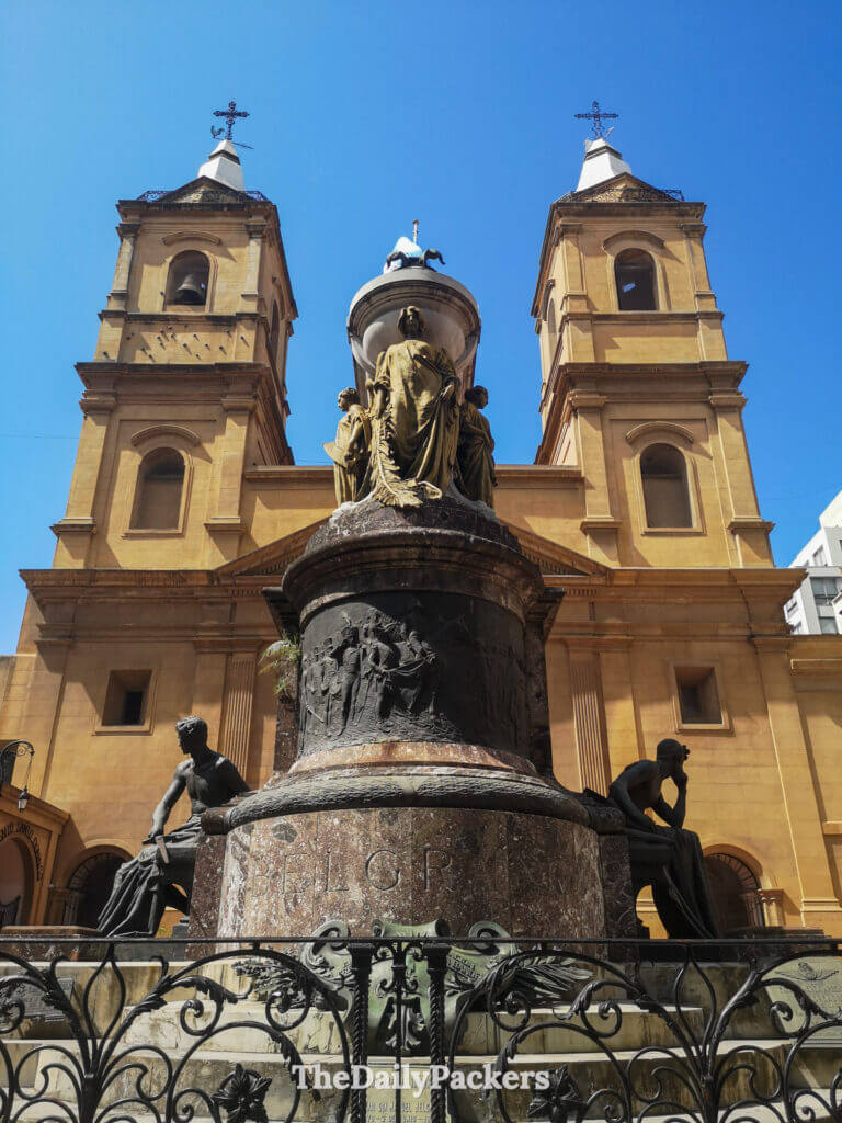 Exterior of Santo Domingo Convent in San Telmo, Buenos Aires, featuring twin bell towers and a historic monument in front