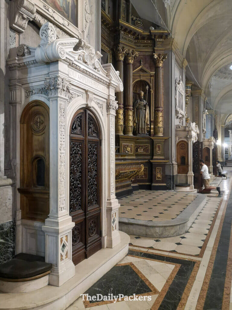 People praying inside Santo Domingo Convent in San Telmo, Buenos Aires, showing the church’s ornate side altars and marble details.