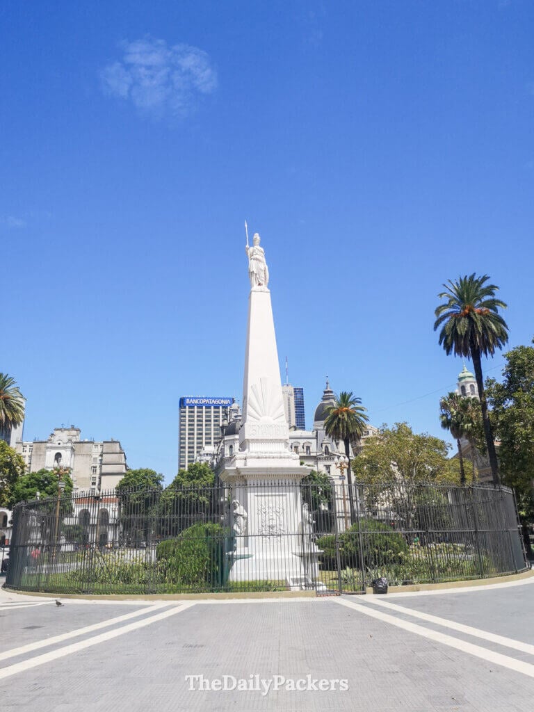 Plaza de Mayo in downtown Buenos Aires, with palm trees, historic monuments, and surrounding government buildings.