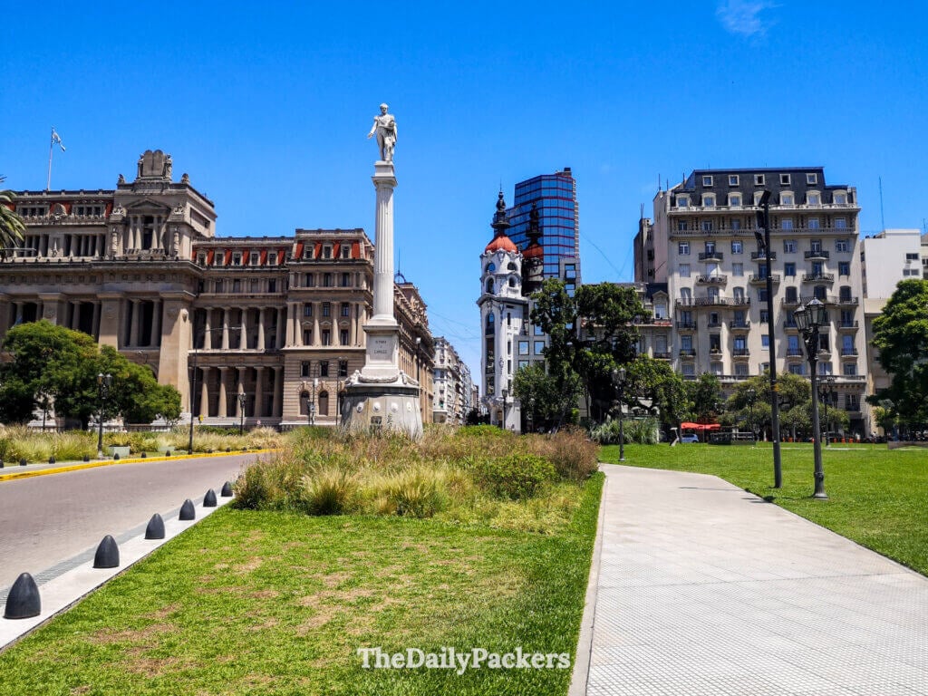 Plaza Lavalle in Buenos Aires with statues, walkways, and surrounding cultural landmarks under a clear blue sky.