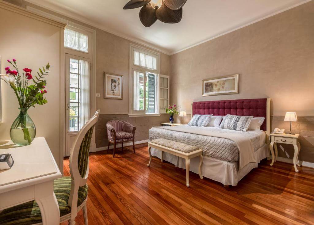 Elegant boutique hotel room at Duque Boutique Hotel in Palermo Soho, Buenos Aires, featuring wooden floors, classic décor, and large windows with natural light.