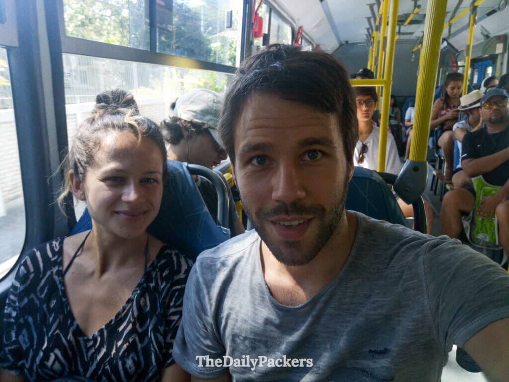 Couple sitting inside a local bus in Florianópolis, a common way to reach trailheads and beaches such as Lagoinha do Leste