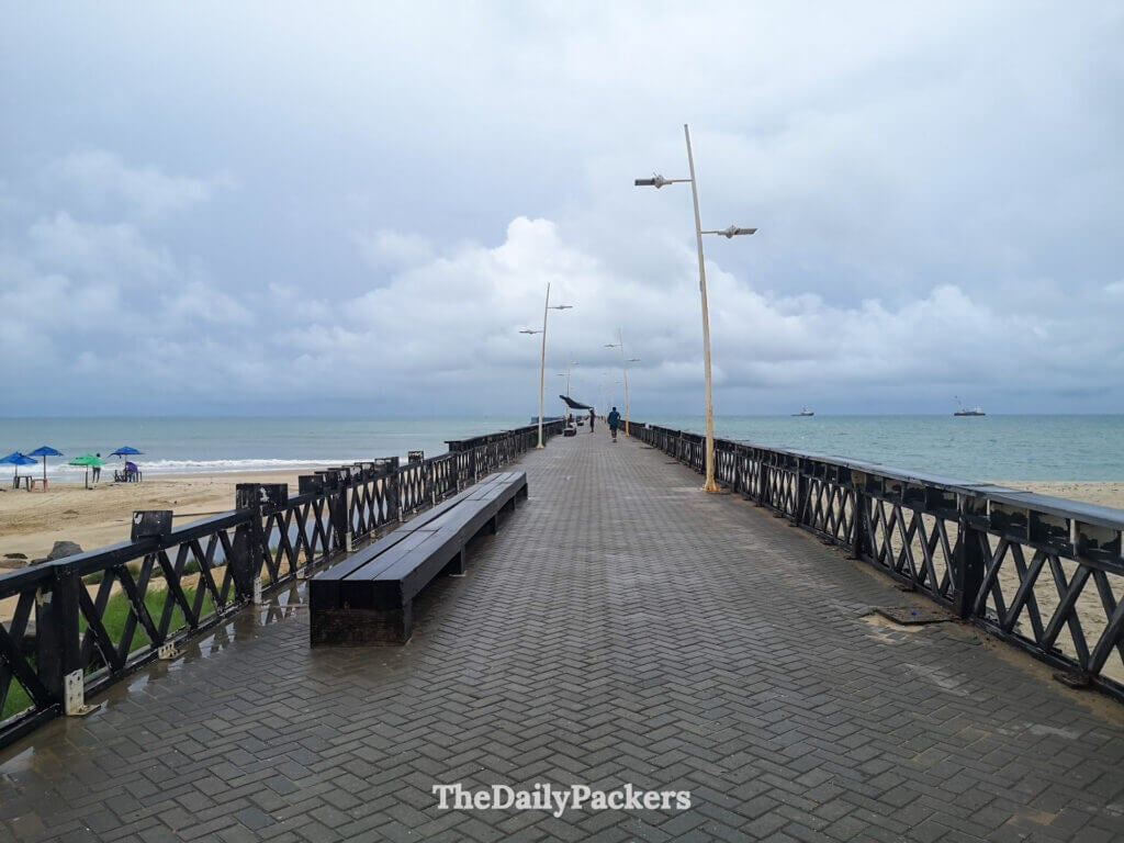 Praia de Iracema pier in Fortaleza extending into the Atlantic Ocean, with beach umbrellas, benches, and cloudy coastal weather