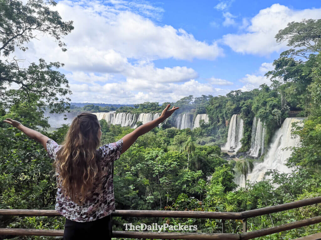 Woman with arms open facing the Sisters Waterfalls on the Iguazu Upper Circuit