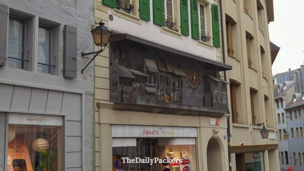 Decorated historic clock facade above Place de la Palud in Lausanne old town