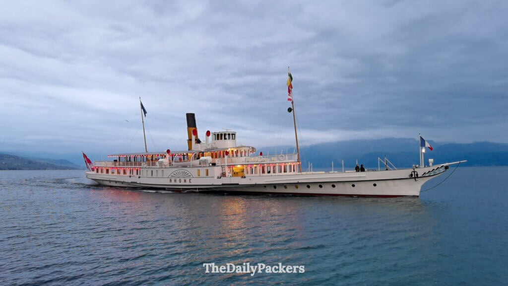 Historic CGN paddle steamer sailing on Lake Geneva near Lausanne at dusk
