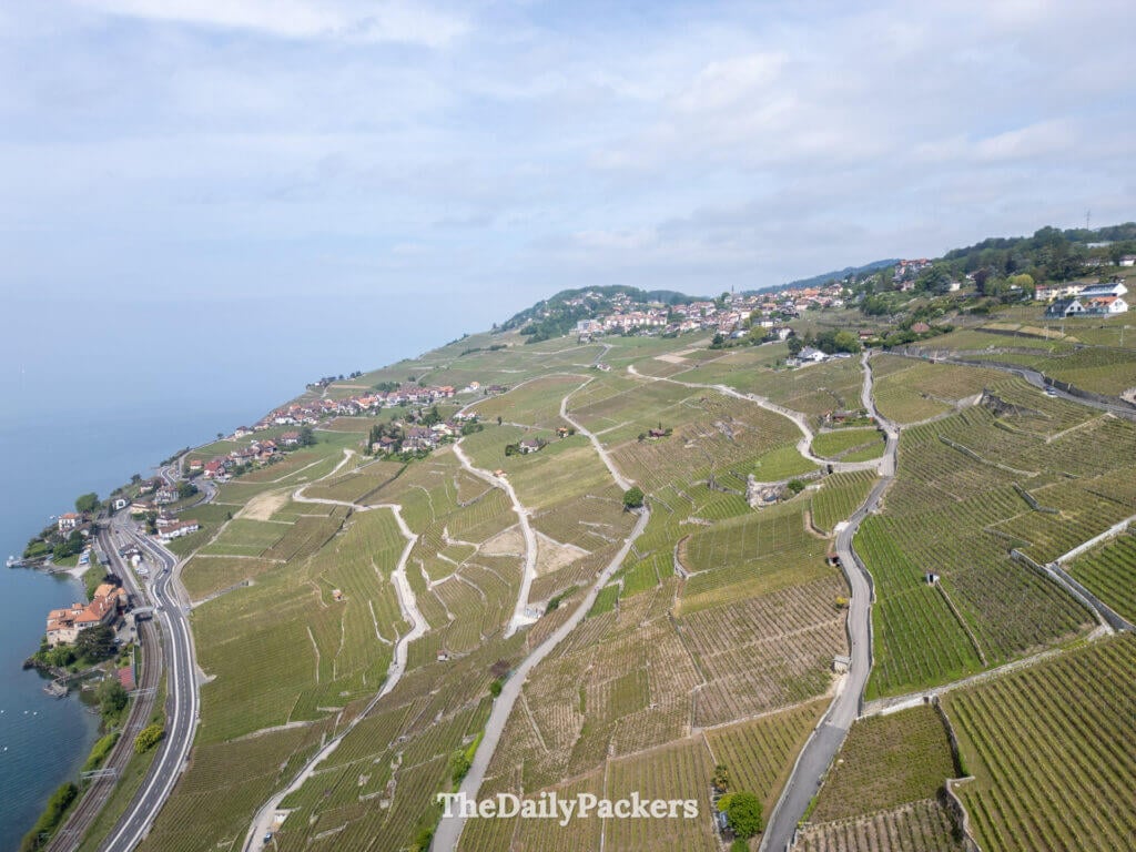 Aerial view of Lavaux vineyards with winding roads and villages along Lake Geneva