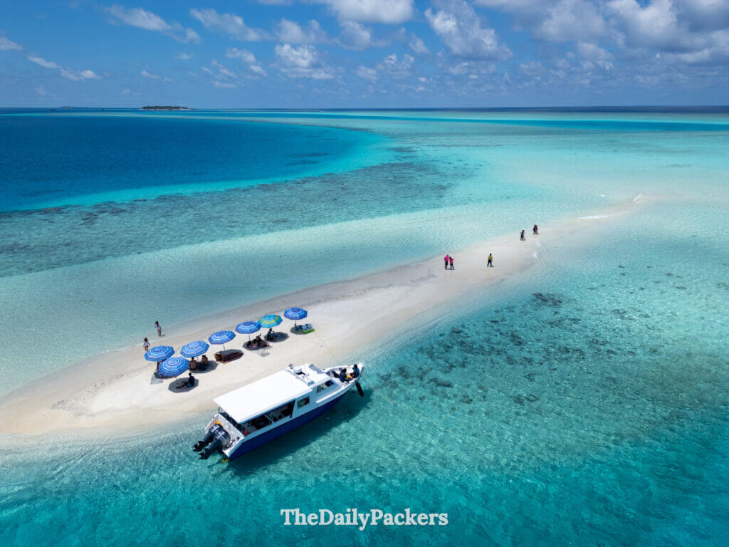 Sandbank tour in the Maldives with boat anchored beside a pristine white beach