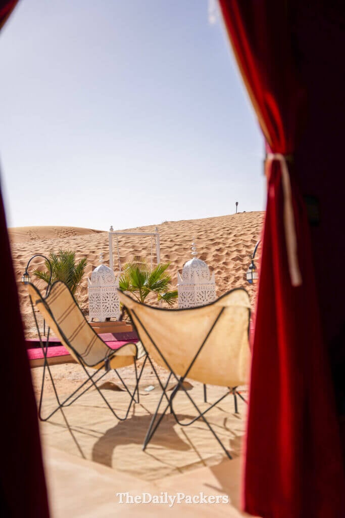 Desert camp lounge setup with chairs and lanterns in the Moroccan Sahara