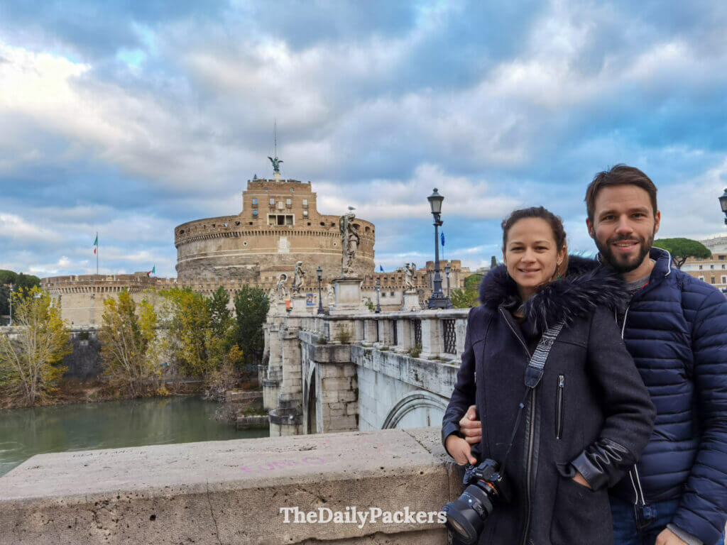 Couple on Ponte Sant’Angelo with Castel Sant’Angelo in the background in Rome