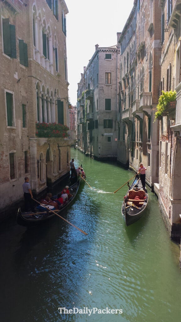 Gondolas passing through a quiet Venetian canal lined with old palazzi