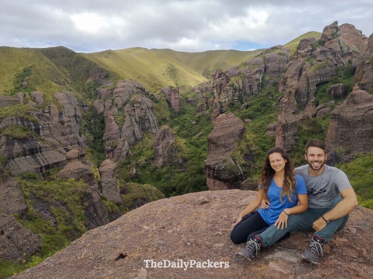 Couple sitting at Los Terrones first viewpoint overlooking green valleys and stone towers
