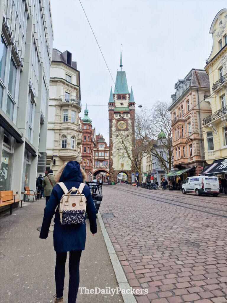 Walking toward Martinstor gate in Freiburg old town, historic streets and tram tracks
