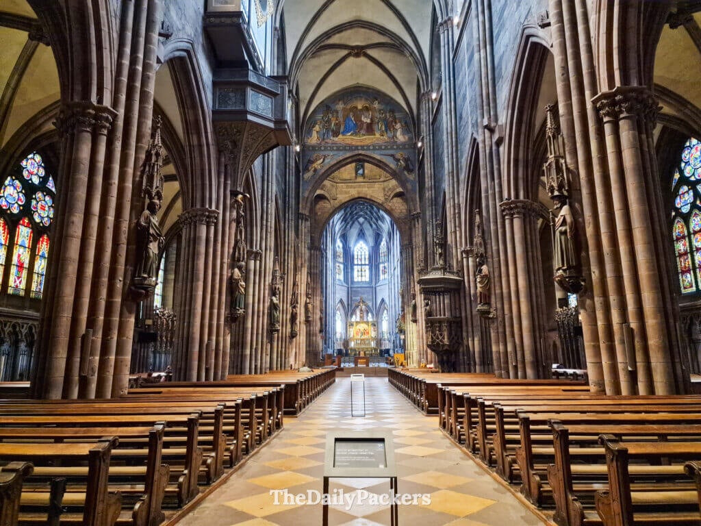 Interior of Freiburg Minster with Gothic columns, stained glass, and central altar
