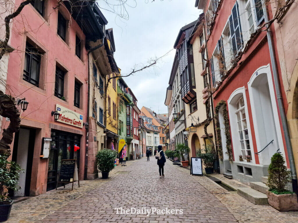 Colorful old town street in Freiburg with cobblestones and small local shops