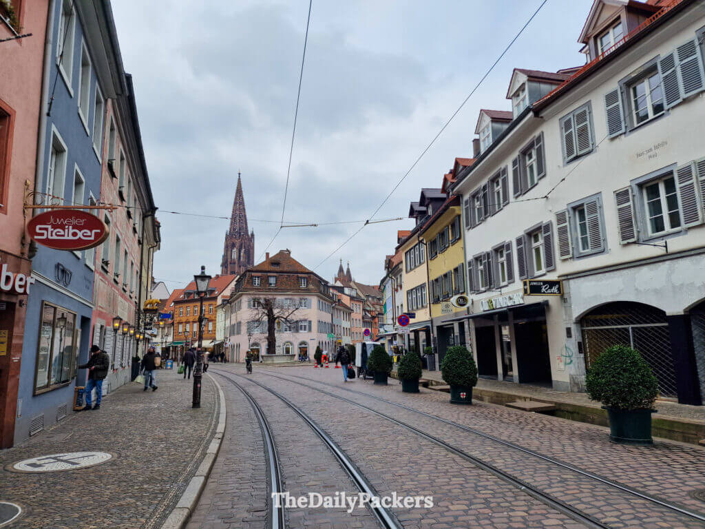 Tram tracks through Freiburg old town with cathedral visible in the distance