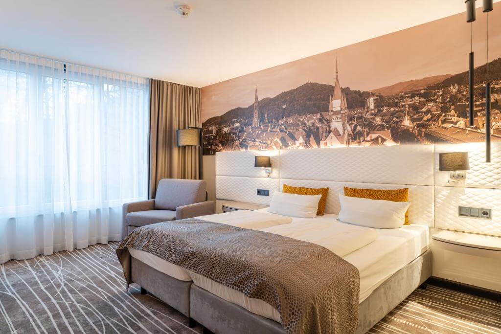 Elegant hotel room at Boutiquehotel am Stadtgarten in Freiburg, bright interior and balcony