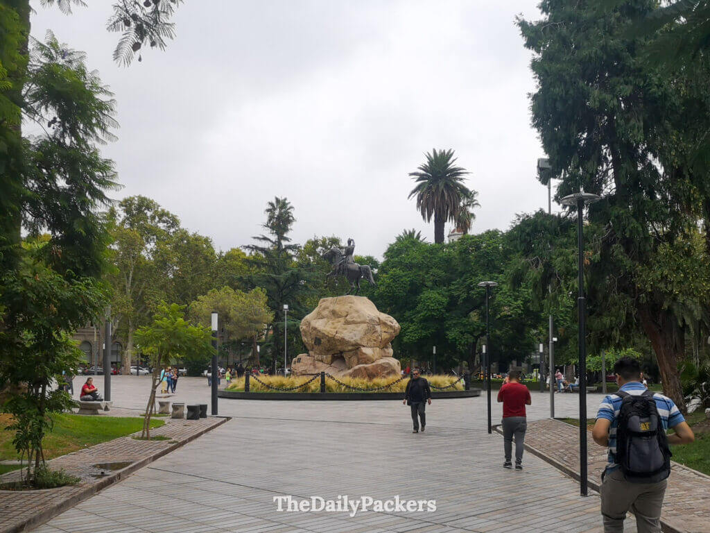 Plaza San Martín à Mendoza avec statue centrale, arbres et habitants se promenant dans le centre-ville