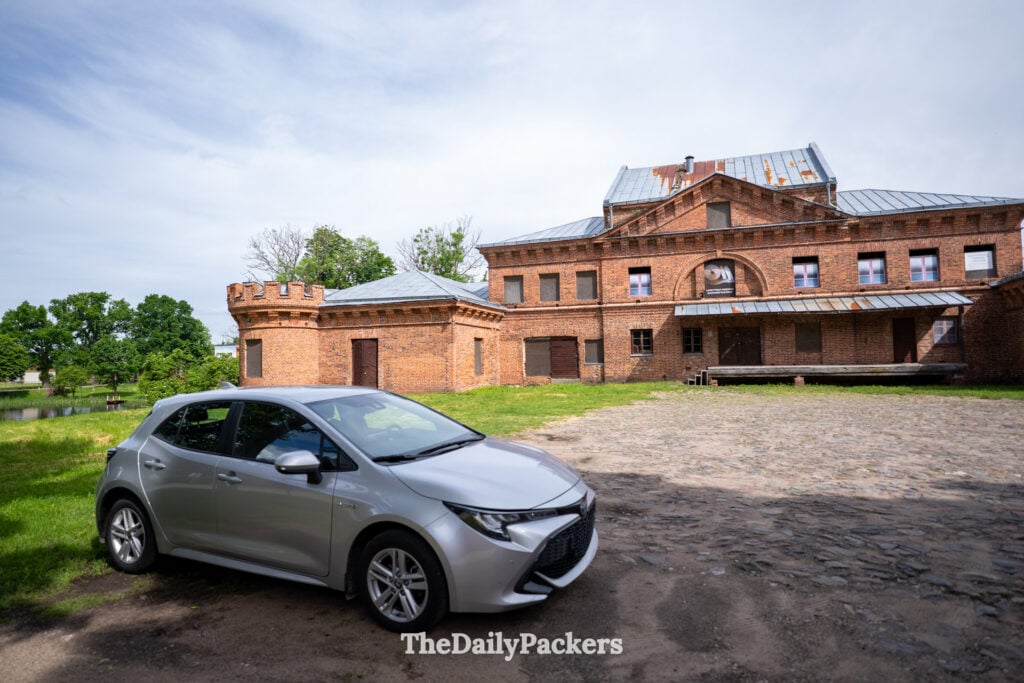 Voiture de location garée devant le château de Raudonė en Lituanie