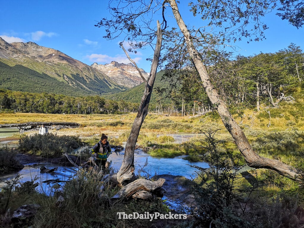 Hiker crossing stream in Laguna Esmeralda valley near Ushuaia