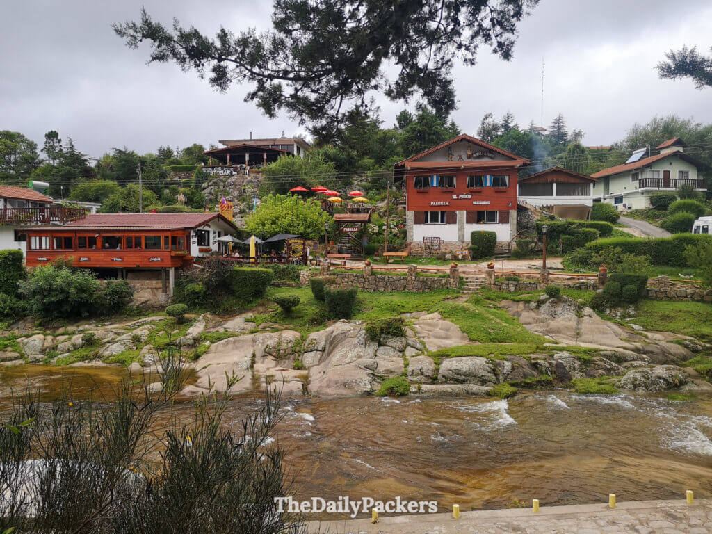 Village view across the river with restaurants and hills in La Cumbrecita