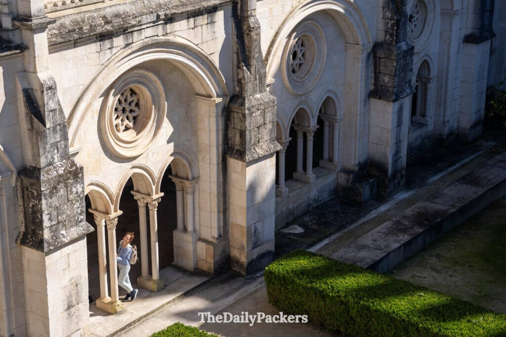 Plan en contre-plongée sur les haies géométriques de buis et les orangers du cloître du monastère.