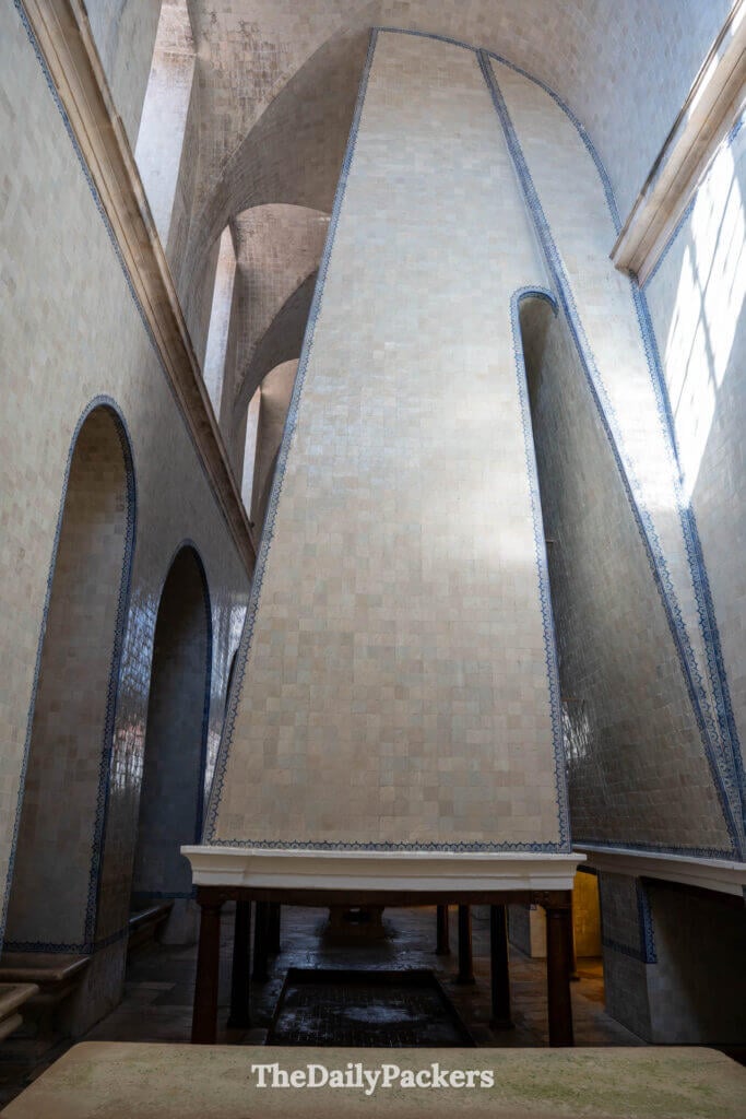 Vue détaillée de l’imposante cheminée centrale recouverte d’azulejos dans la cuisine du monastère d’Alcobaça.