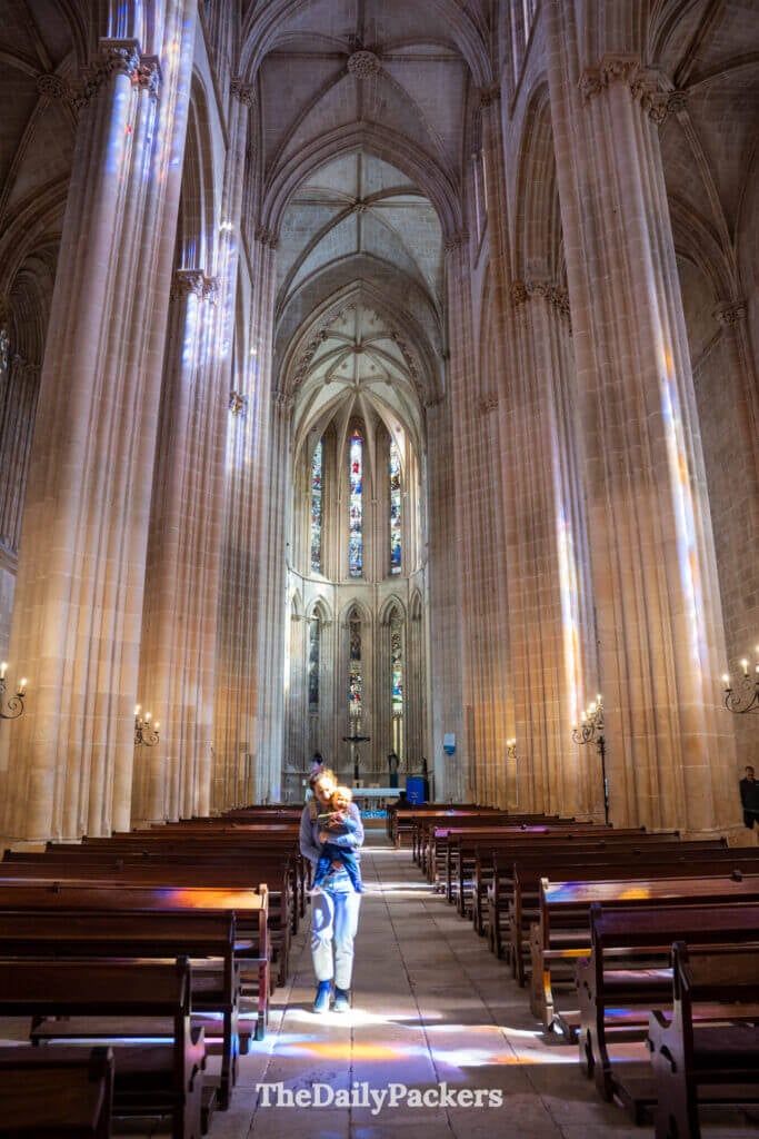 La nef imposante de l'église du monastère de Batalha avec de hautes colonnes et des voûtes d'ogives gothiques.