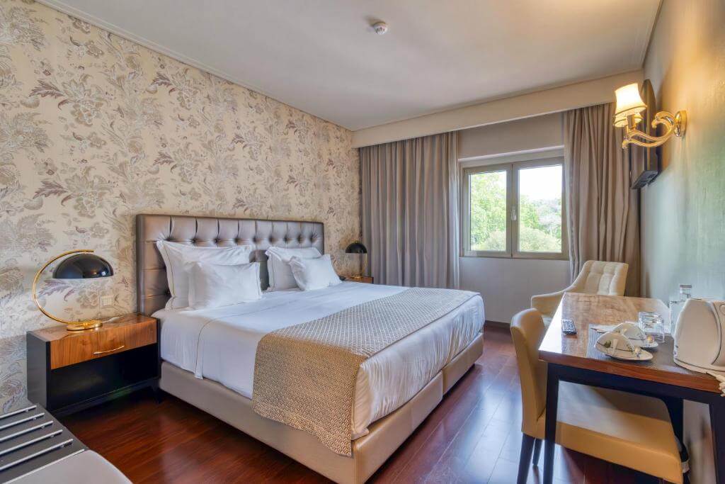 Comfortable modern bedroom at Hotel Lis Batalha with minimalist design and warm lighting.