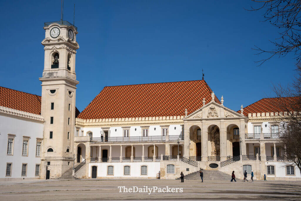 Vue de face du palais royal et de la tour de l'horloge sur la place principale de l'université de Coimbra.