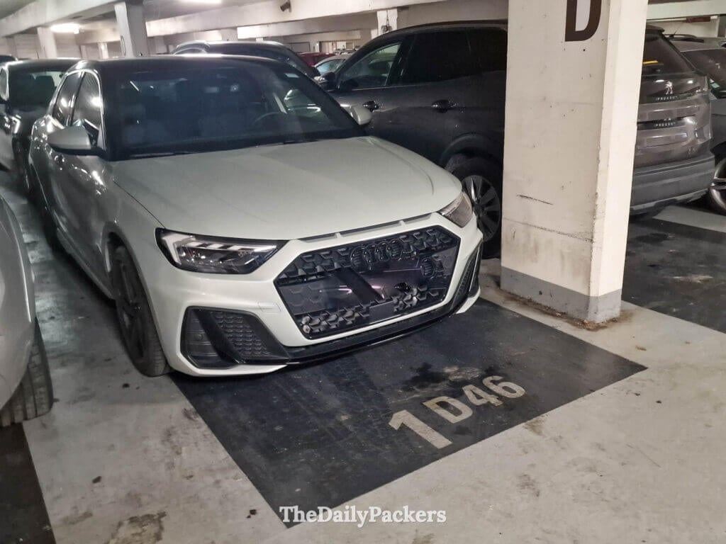 White Audi parked in an underground parking spot labeled 1D46 in Ajaccio, Corsica.