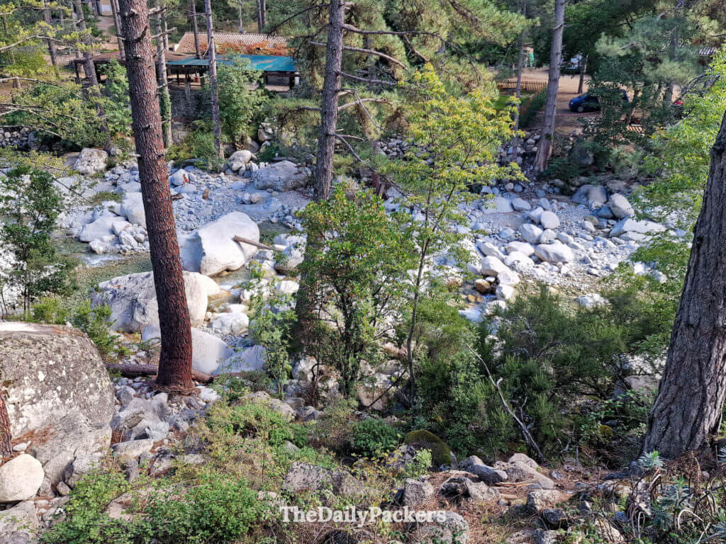 Clear water of the Restonica River rushing over large boulders in Corte, Corsica.