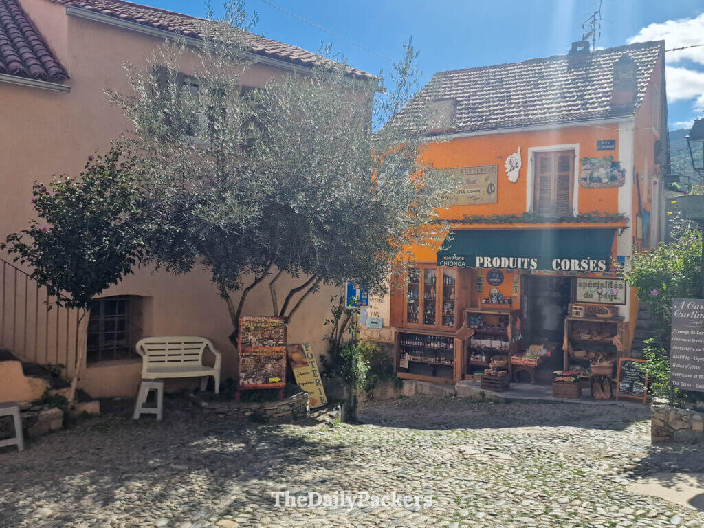 A traditional local products shop on a cobblestone street in Corte, Corsica.