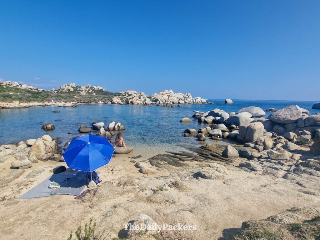 Secluded spot on Lavezzi island with a woman and a sun umbrella