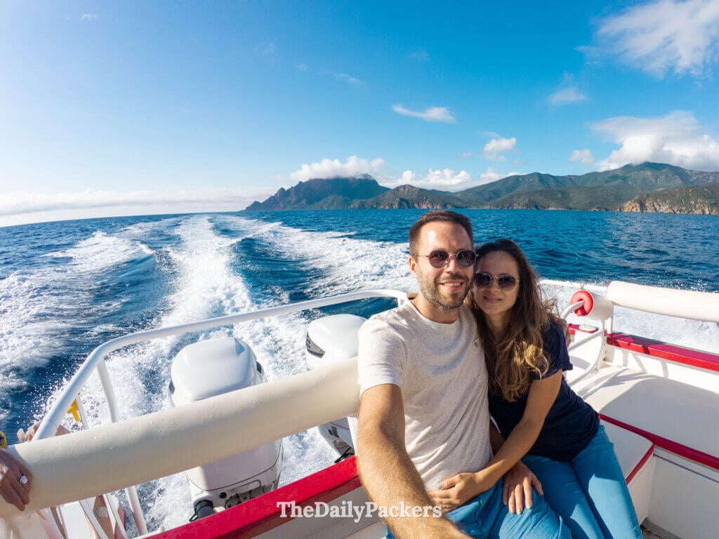 Un couple heureux profite d'une excursion en bateau panoramique le long du littoral volcanique accidenté de la Corse.