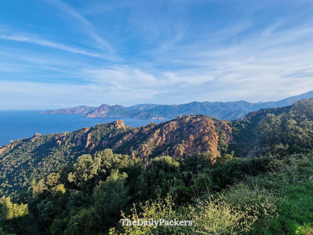 Scenic overview from Piana looking down at deep blue waters surrounded by rugged red rock cliffs.