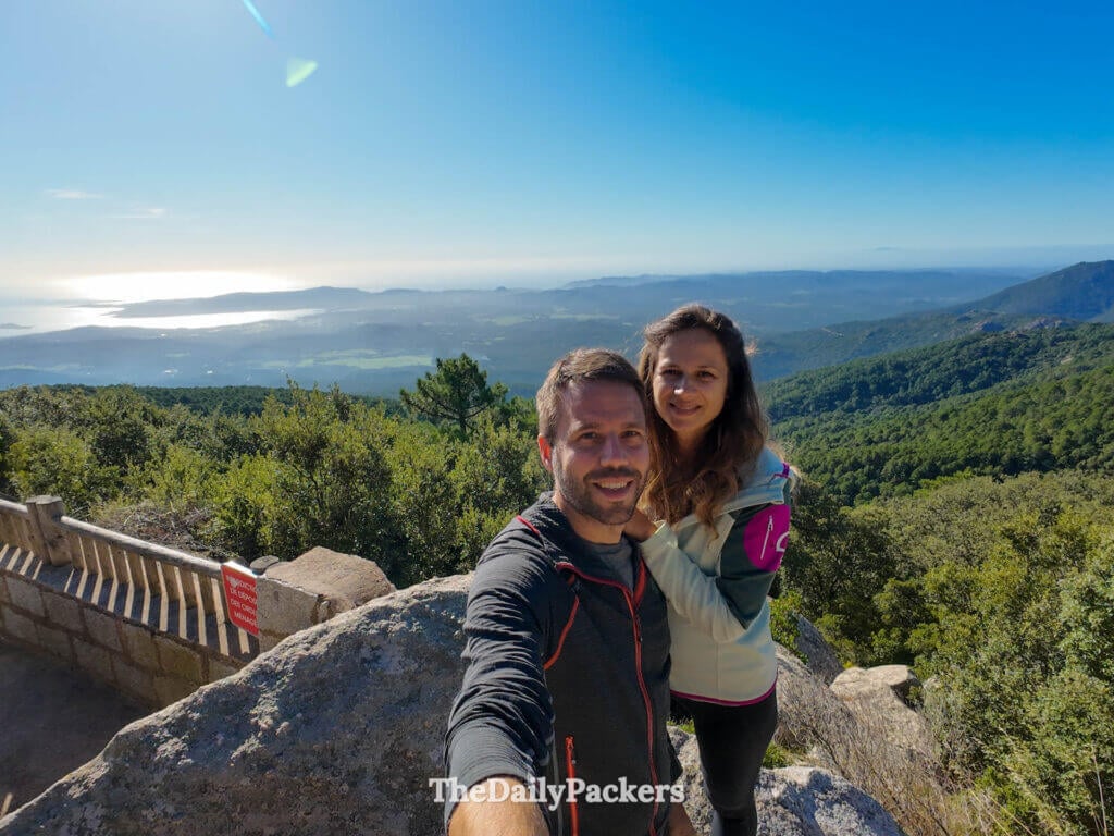 Panoramic viewpoint looking over lush green valleys and distant mountains in Corsica.