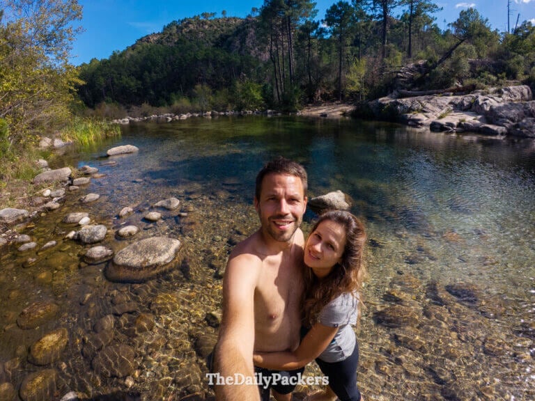 A couple smiling for a selfie together by the natural river rock pools of Solenzara Valley.